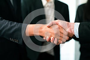 Asian business people shake hand after made successful deal. Quaint