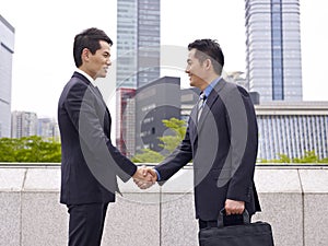 Asian business people shaking hands