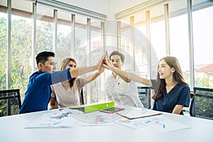 Asian Business people team with casual suit standing and giving high five at office, happy action for teamwork in the modern