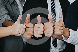 Asian business people thumbs up very good symbol together. Unity and teamwork concept