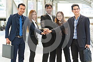 Asian Business Team showing Unity with their hands together