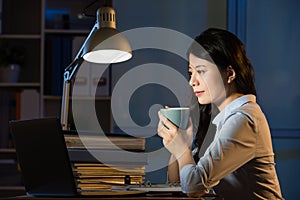 Asian business woman drink coffee refreshing working overtime la