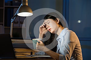 Asian business woman drink coffee refreshing working overtime la photo