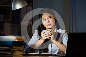 Asian business woman drink coffee working overtime late night