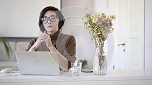 Asian business woman in eyeglasses looking at the camera