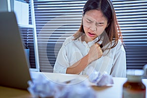 Asian business woman hand pressing on chest with painful expression. Symptoms of heart disease because working too hard.