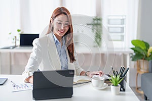 Asian business woman having video call with business team to consult about business plan of company. Online team meeting