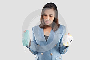 Asian business woman hesitate in choosing a health mask on the gray background