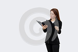 Asian business woman holding and reading document in folder in black suit isolated on white color background