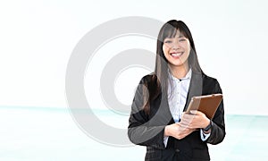 Asian business woman holding smart mobile tablet in office - Young smiling Chinese girl ready for working on digital marketing