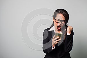 Asian business woman using smart phone. Disappointment and screaming. Portrait on white background with copy space.