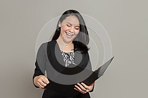 Asian business woman laughing while holding folder