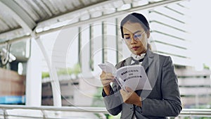 Asian business woman read a business book outside her office, the modern office building background