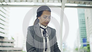 Asian business woman read a business book outside her office, the modern office building background