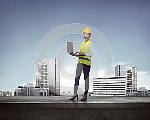 Asian business woman in safety vest standing on the building rooftop