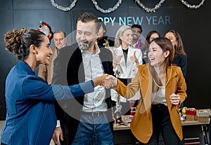 Asian business woman shake hands to her colleague after get the present or gift from new year party of the company