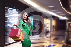 Asian business woman with shopping bags talking on the phone