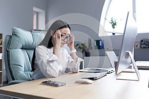 Asian business woman sick working in office, having severe headache, holding hands on head in depression and sad