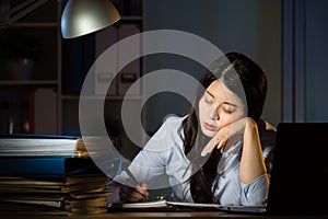 Asian business woman sleepy working overtime late night