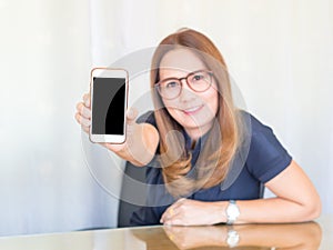 Asian business Woman smiling and holding smart phone device. Smart phone with blank screen. Business Contact concept.