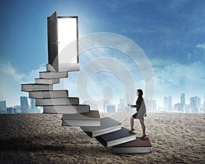 Asian business woman stepping up stair made from book