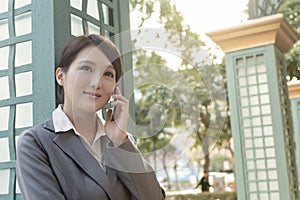 Asian business woman talking on smartphone with copyspace