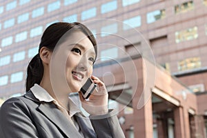 Asian business woman talking on smartphone with copyspace