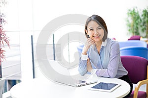 Asian Business woman talking using her headset in the office