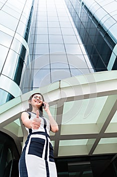 Asian business woman telephoning outside with phone