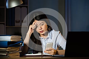 Asian business woman text message by smartphone overtime working