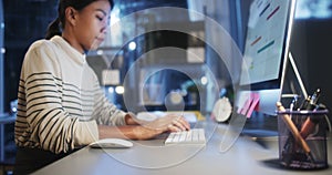 Asian business woman typing keyboard and click mouse, work late night using desktop computer in home office