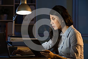 Asian business woman use digital tablet working late overtime
