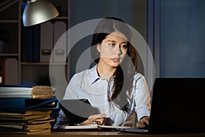 Asian business woman use digital tablet working overtime