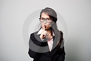 Asian business woman use finger shushing. Sign of quiet.