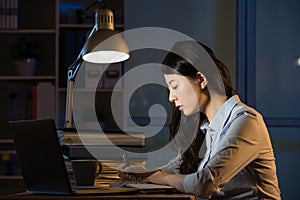 Asian business woman use laptop working overtime late night