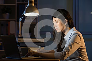 Asian business woman use laptop working overtime late night