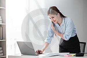 Asian Business woman using calculator and laptop for doing math finance on an office desk, tax, report, accounting