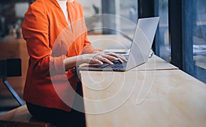 Asian Business woman using calculator and laptop for doing math finance on an office desk, tax, report, accounting, statistics,