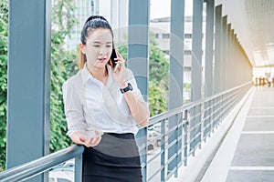 Asian business woman wearing white shirt talking smartphone for