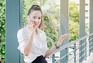 Asian business woman wearing white shirt talking smartphone for