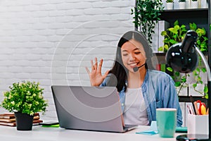 Asian business woman work from home with laptop computer on table with meeting online and video conferencing.Concept of social