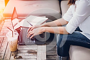 Asian Business woman work typing on laptop with graph data on screen