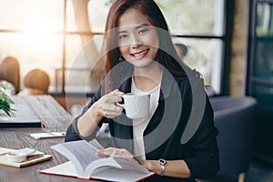 Asian business woman is working and drinking coffee at relaxing