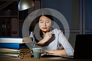 Asian business woman working overtime late night in office