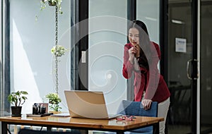 Asian business woman working with thinking moment on laptop. in coffee shop cafe.