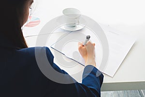 Asian business woman writing signature in document