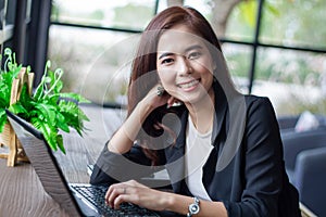 Asian business women using notebook and smart phone and business women smiling happy for working