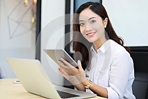 Asian business women using tablet  for working at office relax time and smiling