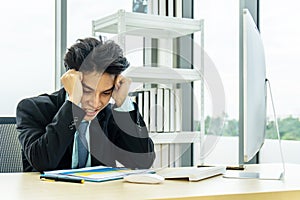 Asian Businessman being depressed by working on the laptop computer in office.Strain,Young business man to think and not Work with