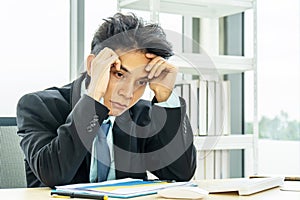 Asian Businessman being depressed by working on the laptop computer in office.Strain,Young business man to think and not Work with